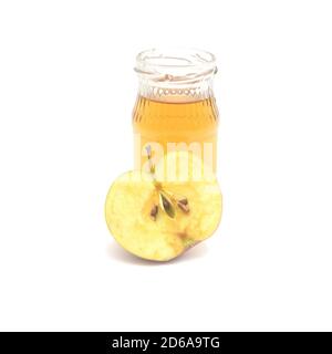 Une demi-pomme et une petite bouteille de vinaigre de cidre de pomme isolée sur fond blanc. Banque D'Images