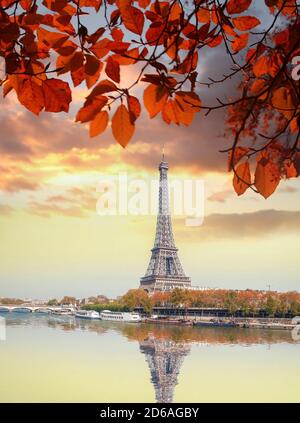 Tour Eiffel avec feuilles d'automne contre un coucher de soleil coloré à Paris, France Banque D'Images