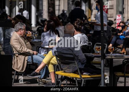 Les clients d'une terrasse de bar sur la Rambla de Catalunya sont vus apprécier leurs boissons quelques heures avant la fermeture obligatoire.le gouvernement catalan commande de ce soir la fermeture totale des bars, restaurants et terrasses en raison de l'augmentation des infections de Covid19 en Catalogne, pouvoir servir uniquement des plats à emporter. Banque D'Images