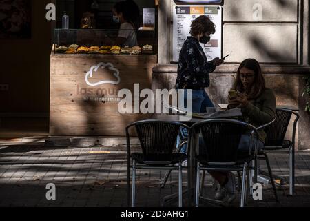 Les clients d'une terrasse de bar sur la rue Ronda de Sant Pera sont vus apprécier leurs boissons quelques heures avant la fermeture obligatoire.le gouvernement catalan commande à partir de ce soir la fermeture totale des bars, restaurants et terrasses en raison de l'augmentation des infections de Covid19 en Catalogne, pouvoir servir uniquement des plats à emporter. Banque D'Images