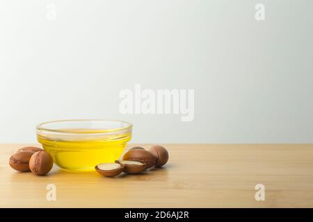 Fond d'huile d'argan. Noix d'argan et huile sur une table en bois sur fond blanc vide. Copier l'espace Banque D'Images