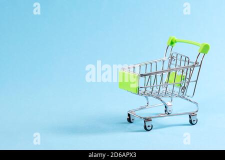 chariot vide sur fond bleu, mini chariot métallique isolé sur fond coloré avec un emplacement pour le texte Banque D'Images
