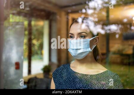 Femme portant un masque de protection dans le bureau pour des raisons de sécurité Et protection pendant COVID-19 Banque D'Images