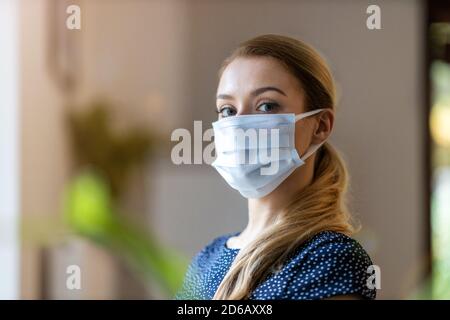 Femme portant un masque de protection dans le bureau pour des raisons de sécurité Et protection pendant COVID-19 Banque D'Images