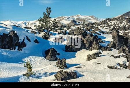 La neige couvre certaines des formations de lave noires qui sont parmi les caractéristiques du monument national Craters of the Moon et de préserver qui s'étend sur la plaine de la rivière Snake dans l'Idaho, aux États-Unis. Ce paysage particulier est le résultat de huit éruptions volcaniques majeures qui ont commencé il y a 15,000 ans et se sont poursuivies jusqu'à il y a seulement 2,000 ans. Les géologues prédisent que la région fera l'expérience d'une autre éruption dans les 100 à 900 prochaines années. Une route à boucle de 7 kilomètres (11 milles) permet aux visiteurs de visiter la réserve en voiture, et de nombreux sentiers encouragent d'autres explorations à pied. Banque D'Images