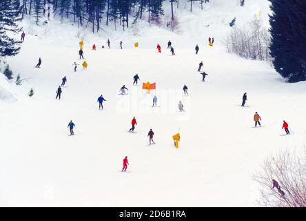 Les skieurs et les surfeurs des neiges descendant les pistes enneigées de Bald Mountain s'étendent près du fond du sentier River Run à leur retour dans leurs logements de vacances d'hiver dans les villes populaires de Ketchum et Sun Valley dans l'Idaho, aux États-Unis. Tout au long de la saison hivernale, de nombreux télésièges et cabines de télécabines transportent les skieurs, les snowboardeurs et les touristes sur les flancs enneigés des montagnes jusqu'aux têtes de sentiers et aux panoramas pittoresques des Smoky Mountains. Banque D'Images