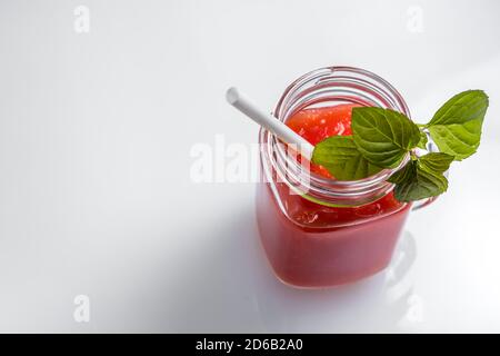 Smoothie au melon d'eau dans un pot avec des feuilles de menthe et un Cocktail Straw et espace pour le texte Banque D'Images