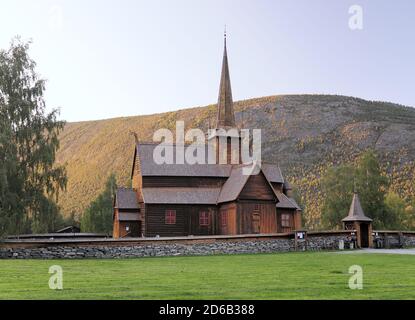 Belle église de la Stave en bois de LOM entourée par les montagnes et Arbres dans le parc national de Jotunheimen lors D'UNE journée ensoleillée d'été Avec UN ciel bleu clair Banque D'Images