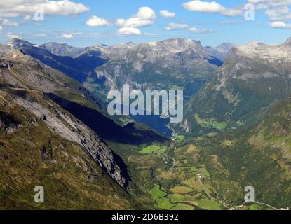 Vue depuis le point de vue de Dalsnibba jusqu'aux grandes montagnes du Geirangerfjord Un soleil d'été avec UN ciel bleu clair Et quelques nuages Banque D'Images