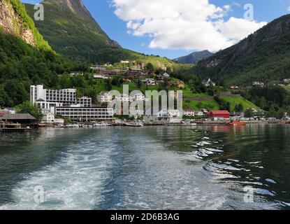 Vue depuis UN bateau jusqu'au village de Geiranger dans le Geirangerfjord Un soleil d'été avec UN ciel bleu clair Et quelques nuages Banque D'Images