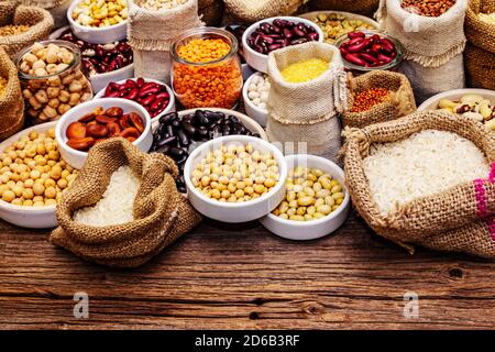 Assortiment de différents types de grains de haricots et de céréales. Ensemble de sources indispensables de protéines pour un mode de vie sain. Ancienne table en bois Banque D'Images