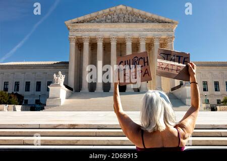 Washington, DC, Etats-Unis, 15 octobre 2020. Photo : une femme détient deux moitiés d'un panneau prônant la séparation de l'église et de l'état pendant les Handmaid descendre sur la Cour suprême protestation tenue par refuser fascisme DC. Pour l'événement, des femmes vêtues de servantes en capes rouges du Tale de la servante se sont élevées devant le bâtiment de la Cour suprême pour protester contre la nomination d'Amy Coney Barrett et les politiques fascistes de l'Administration Trump. La manifestation a continué de refuser la demande du fascisme de destitution immédiate de Donald Trump et de Mike Pence. Crédit : Allison C Bailey/Alay Live News Banque D'Images