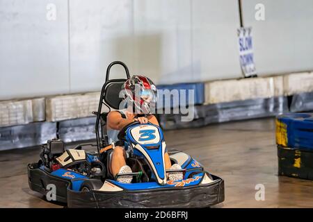 Mackay, Queensland, Australie - Janvier 2020 : une femme conduit un go-kart dans un circuit d'entraînement de loisirs autour d'un en public Banque D'Images