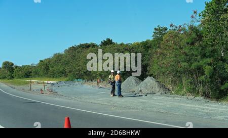 MacKay, Queensland, Australie - juin 2020 : deux travailleurs qui ne parlent pas et arpentant une pile de gravier pendant les travaux routiers Banque D'Images