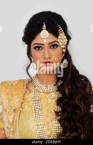 Femme en mariage jaune sari et bijoux en argent. Regarder l'appareil photo Banque D'Images