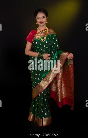 Modèle indien portant le traditionnel Maharashtrian mariage vert sari et bijoux. Regarder la caméra. Prise de vue en longueur Banque D'Images
