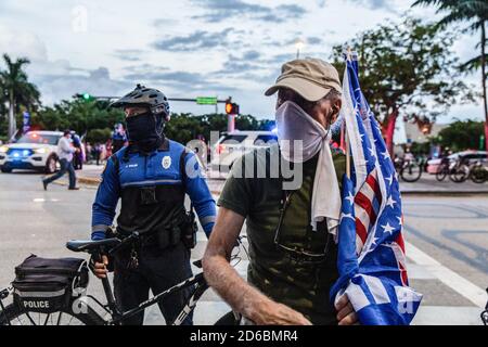 La police de Miami forme des barrières de part et d'autre de Biscayne Boulevard pour maintenir les groupes de protestants pro Trump et anti Trump éloignés les uns des autres dans la rue où le président Trump a tenu une mairie à Miami.des manifestants pour et contre le président Trump se sont rassemblés ce soir dans le centre-ville de Miami où Le président a tenu une réunion avec NBC News où le débat présidentiel devait avoir lieu avant son annulation. Le président a programmé cette mairie pour rivaliser avec la mairie de Joe Biden et ABC News en Pennsylvanie et leurs événements ont eu lieu à la place de l'annulation de Presi Banque D'Images