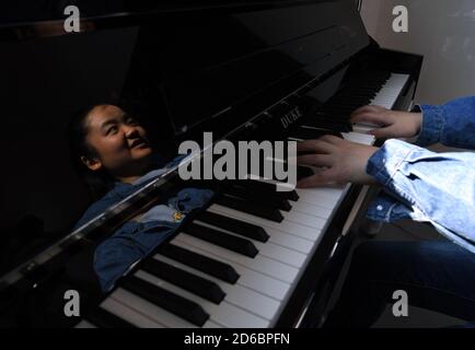 (201016) -- BEIJING, le 16 octobre 2020 (Xinhua) -- Wang Xiangjun se reflète sur le piano comme elle enseigne dans une leçon de piano au Centre d'éducation spéciale Hefei à Hefei, province d'Anhui en Chine orientale, le 12 octobre 2020. Le Wang Xiangjun, 24 ans, qui est aveugle en congénito, a un rêve -- enseigner aux enfants malvoyants comment jouer au piano. Wang a été présenté pour la première fois à la musique par sa grand-mère, qui était enseignante de musique à l'école primaire. Mais elle n'a pas commencé à apprendre à jouer du piano tant qu'elle n'a pas été envoyée pour étudier au Centre d'éducation spéciale Hefei de la province d'Anhui en Chine orientale. 'Ma Banque D'Images