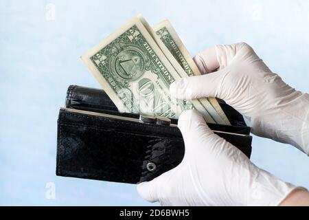 femme prenant de l'argent hors portefeuille femelle portant des gants en caoutchouc pour prévenir la propagation de bactéries ou de virus, faire des achats pendant la pandémie de coronavirus Banque D'Images
