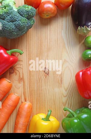 Image verticale de légumes frais assortis colorés cadre sur bois arrière-plan Banque D'Images