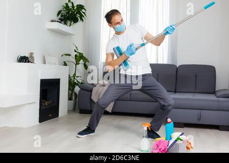 concept de nettoyage, de santé et d'hygiène - indien portant un masque médical de protection contre les maladies virales dans des gants avec un détergent et une vadrouille Banque D'Images