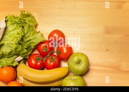 Service de livraison de nourriture. Nourriture saine sur table en bois. Acheter en ligne pendant la quarantaine. Tomates, pommes, bananes, oranges, salade. Photo de haute qualité. Séjour Banque D'Images