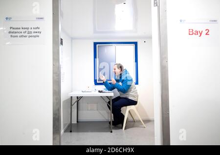 Andrew Ilesley explique comment utiliser une trousse d'auto-test au nouveau centre de test de Covid à Dundee. Le centre d'essai utilise un système de remorques reliées nettoyées à l'aide de glace sèche, le premier site en Écosse à avoir cette capacité. Banque D'Images