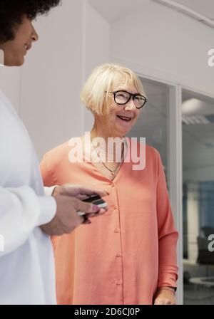 Femme souriante parlant avec des collègues Banque D'Images