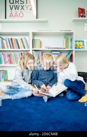 Les enfants cherchent à réserver ensemble Banque D'Images