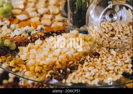 Gros plan de différents types de fromage, noix et arachides sur une table de banquet. Banque D'Images
