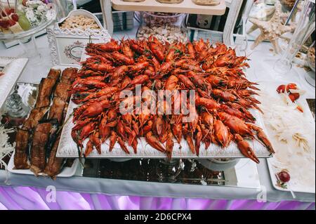 Grande assiette carrée de délicieux écrevisses et homards avec sur la table du buffet de mariage. Banque D'Images