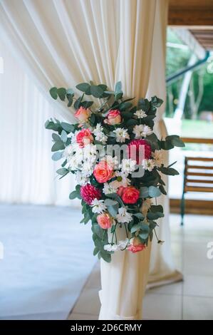 Fleurs de roses, pâquerettes, chrysanthèmes et feuilles d'eucalyptus dans la salle de banquet. Banque D'Images