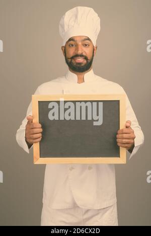 Beau jeune homme indien chef contre l'arrière-plan gris Banque D'Images