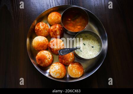 Une vue de dessus du traditionnel padou indien du sud (riz appe) avec sambar, chutney isolé dans une plaque sur une table en bois Banque D'Images