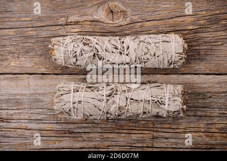 Des paquets de sauge blanche séchée sur un arrière-plan en bois vieilli vieux.fumée d'Aroma pour l'énergie de compensation et de guérison.gros plan avec l'espace pour le texte. Banque D'Images