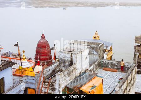 Varanasi, Uttar Pradesh, Inde : UN garçon regarde le fleuve Ganges depuis un toit à côté du temple de Baba Mashan Nath, à la crémation de la Ghat de Manikarnika Banque D'Images