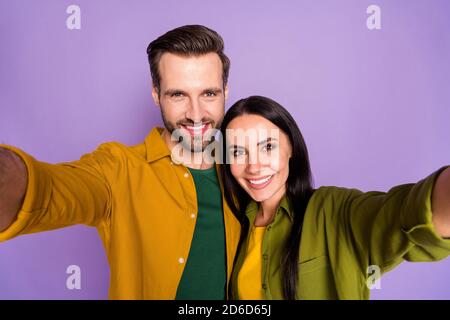 Gros plan photo de la jolie dame joyeuse gars beau couple passer mettre en quarantaine ensemble faire des selfies les blogueurs portent des chemises brillantes isolées pourpre couleur Banque D'Images