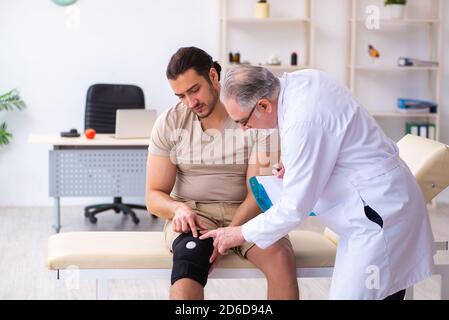 Jeune homme rendant visite à un médecin expérimenté à l'hôpital Banque D'Images