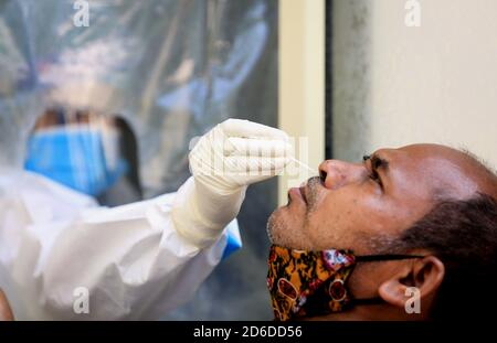 New Delhi, Inde. 16 octobre 2020. Un travailleur de la santé prélève un échantillon d'écouvillon auprès d'un homme au cours d'un test de dépistage COVID-19 dans un hôpital de New Delhi, Inde, le 16 octobre 2020. Credit: Partha Sarkar/Xinhua/Alamy Live News Banque D'Images