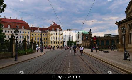 Dresde, Allemagne - 06/16/2018: Rue pavée Sophienstraße en direction sud avec tramway, vélo touristes et complexe de construction Zwinger. Banque D'Images