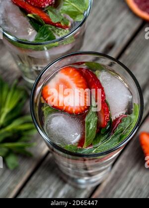 Cocktails à la fraise et à la menthe fraîchement préparés sur une table en bois Banque D'Images