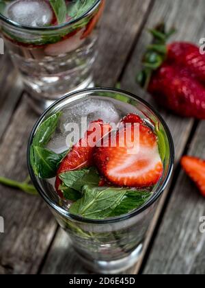 Cocktails à la fraise et à la menthe fraîchement préparés sur une table en bois Banque D'Images