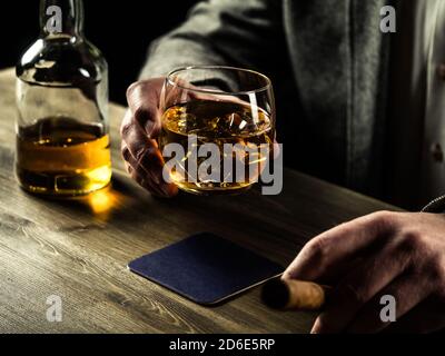 Homme bien habillé avec un cigare buvant le whisky Banque D'Images