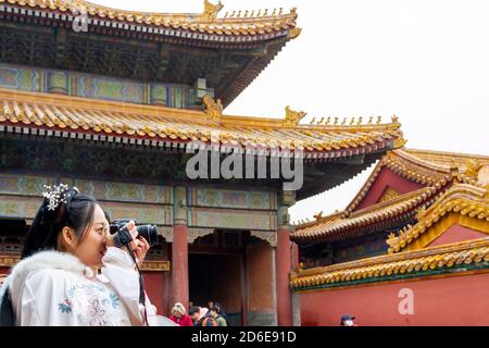 Beijing, Chine - novembre 21 2019 : une jeune chinoise vêtue de vêtements chinois traditionnels dans des tons blancs, prend des photos dans le CIT interdit Banque D'Images