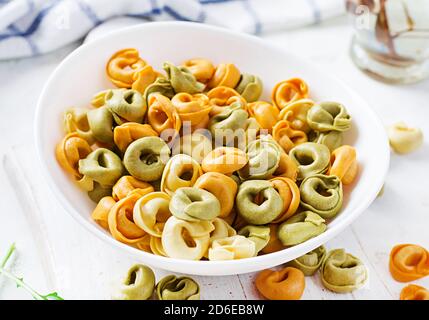 Pâtes tortellini fourrées au fromage dans un bol blanc. Pâtes italiennes. Banque D'Images