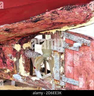 Vieux bateau de pêche galicien en bois rouge dans un port. Stern, PROPELLER et de la barre en gros plan. Galice, Espagne. Banque D'Images
