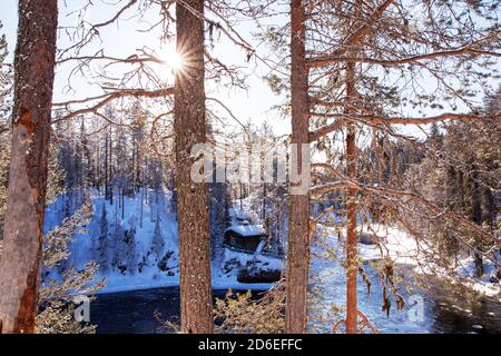 Une petite cabane d'hiver confortable au bord de la rivière dans la forêt finlandaise de taïga, en Europe du Nord. Banque D'Images