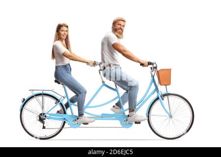 Un couple heureux avec des tenues assorties, à cheval sur un vélo en tandem isolé sur fond blanc Banque D'Images