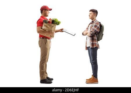 Photo pleine longueur d'un homme livrant des produits alimentaires et donner un document à un jeune étudiant isolé sur arrière-plan blanc Banque D'Images