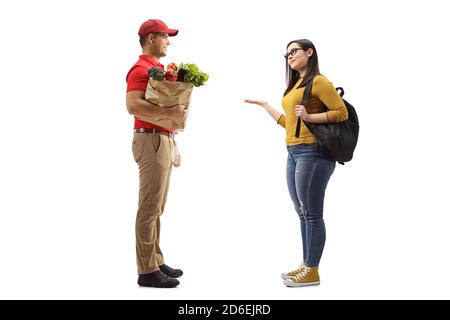 Prise de vue sur toute la longueur d'un homme délivrant un sac de l'alimentation à une étudiante femelle isolée sur fond blanc Banque D'Images